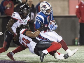 Redblacks linebacker Taylor Reed pulls down Alouettes running back Tyrell Sutton during the fourth quarter of Thursday's game in Montreal. THE CANADIAN PRESS/Paul Chiasson