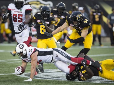 Redblacks fullback Patrick Lavoie (81) is tackled by Tiger-Cats linebacker Larry Dean (11) during the first half of Friday's game at Hamilton. THE CANADIAN PRESS/Peter Power