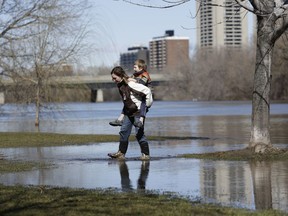 Alex Newman gets a piggy back from his mom Candace to cross a flooded section of Brighton Beach Park on March 8, 2017.