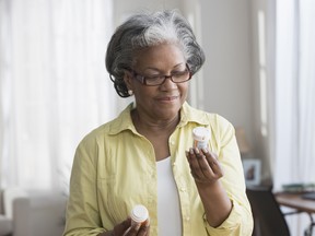 Black woman reading prescription bottles