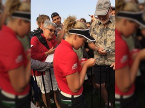 Brooke Henderson signs a golf ball for Al Pollock and gives him a golf glove after hitting him with a drive during the second round of the Canadian Women's Open on Friday, Aug. 25, 2017 at the Ottawa Hunt and Golf Club.