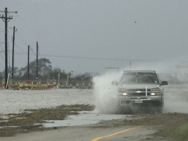 A motorist drives through a flooded highway in the aftermath of Hurricane Harvey Saturday, Aug. 26, 2017, near Port Lavaca, Texas.