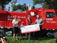 Canadian Golf Hall of Fame member Lorie Kane- left- and child ambassador Zander Zatylny react as Canadian Pacific president and CEO Keith Creel presents a cheque for -2 million to Kevin Keohane- president and CEO of the CHEO Foundation at Ottawa Hunt and Golf Club on Sunday- Aug 27- 2017.