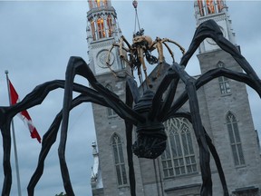 Kumo, the spider from La Machine, perches atop Notre Dame Cathedral, looking down on Maman the spider in front of the National Gallery.
