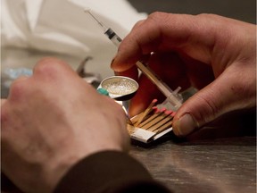 A man prepares heroin he bought on the street.