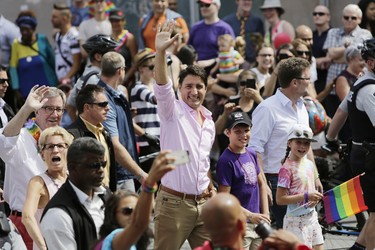 Prime Minister Justin Trudeau marches for the first time in Ottawa's Capital Pride parade, with his son Xavier and daughter Ella-Grace, and joined by Mayor Jim Watson, as big crowds turned out in Centretown to take in the festivities on Sunday, Aug. 27, 2017. (David Kawai)