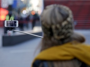 Sandy Johal uses a selfie stick to take a picture of herself in Times Square in New York, Thursday, Jan. 8, 2015. (AP Photo/Seth Wenig) 
stock photo
STK_
Seth Wenig, AP