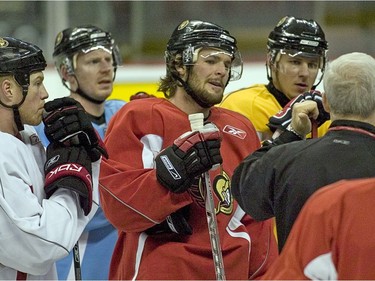 Chris Neil, far left, and Mike Fisher, middle, join Senators teammates in listening to the comments of Bryan Murray, then the team's head coach, during a practice before the 2007 Eastern Conference final against the Buffalo Sabres.