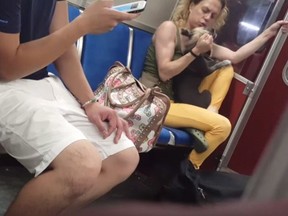 A woman grabs a dog in a screengrab from a video posted to YouTube in a handout photo. Authorities in Toronto have seized a dog that police say was seen in an online video being hit by its owner on a subway train.The Ontario Society for the Prevention of Cruelty to Animals took the dog after executing a search warrant on Monday and charges are pending against the owner, OSPCA spokeswoman Alison Cross said Tuesday.
