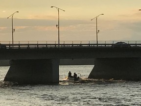 The Ottawa Fire Service water rescue boat heads upstream at Champlain Bridge after a caller saw a green canoe overturn in the Ottawa River early Tuesday even.