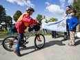 James Potvin, 9, is welcomed by his family at Mooney's Bay after completing a ride for autism with his father, Chris, not pictured. They biked more than 400 kilometres from Whitby, Ont., to Ottawa during the past week.