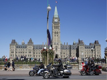 Bikers Against Child Abuse ride past the Parliament Buildings in Ottawa on Saturday, Sept. 3, 2017.