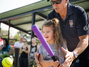 Eight-year-old Ashlyn Piche-Fufton shows off her ball skills with a little help from Ottawa police Inspector Pat Flanagan.