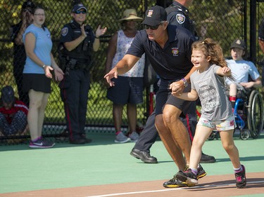 Eight-year-old Ashlyn Piche-Fufton shows off her ball skills with a little help from Ottawa police Inspector Pat Flanagan.