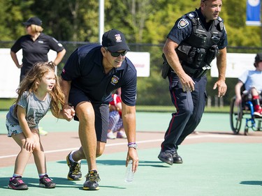 Eight-year-old Ashlyn Piche-Fufton shows off her ball skills with a little help from Ottawa police Inspector Pat Flanagan.