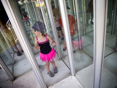 Four-year-old Caroline McIver tries to make her way through a maze of windows at the Richmond Fair.