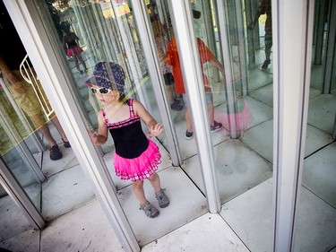 Four-year-old Caroline McIver tries to make her way through a maze of windows at the Richmond Fair.