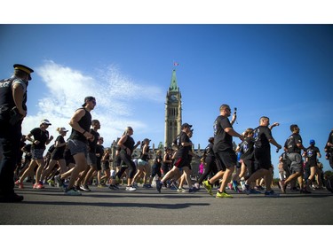 Runners push past the Parliament Buildings on Saturday, Sept. 23, 2017.