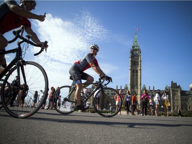 Cyclists pass by the Parliament Buildings.