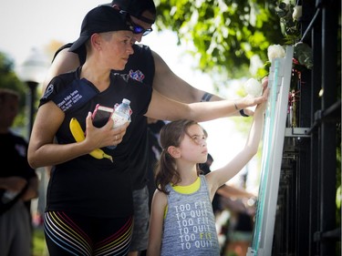 Cindy Cybulski and her daughter, seven-year-old Katie, make their way along the Canadian Police and Peace Officers' Memorial, touching the top of each list of officers killed on duty.