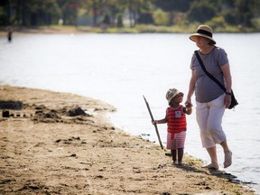 Jayden Mathieu Ishimwe, 21 months, walks along the beach with Therese Lizotte while enjoying the warm weather at Mooney's Bay beach Saturday, September 23, 2017.
