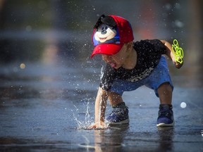 Ottawa set heat and humidity records Sunday and it's going to stay hot Monday and Tuesday. One-year-old Nayden cooled off at Lansdowne's water plaza Sunday September 24, 2017.