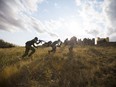 Players on the Allied team run to cover on top of hill during a WW2 re-enactment at Prairie Storm Paintball near Moose Jaw, September 17, 2017.