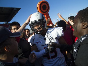 Carleton's Trevor Hoyte (43) celebrates on the field with Ravens fans after Saturday's overtime victory against the Gee-Gees.   Ashley Fraser/Postmedia