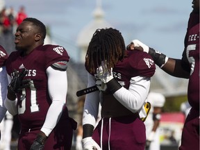 Prior to the Panda Game, there was a moment of silence held in honour of Loic Kayembe, the Gee-Gees' defensive lineman who died in his sleep a week ago. From left, are Shako Dimanche, Jermaine Wright and Ibra Ndiaye.