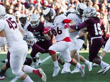 Quinton Soares of the Ravens tries to get away from Gee-Gees tacklers. Soares returned one punt 84 yards for a touchdown on Saturday.   Ashley Fraser/Postmedia