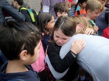 - First day at a new school is tough at any age and young Cadence Merkely, 7, got reassurance from her mom, Christiane Holst, before filing into her grade two lineup in the school yard.  It was the first day back at school for kids in Ottawa's public board Tuesday (Sept. 5, 2017). However, for almost 600 children, it was their first day at a new school, Vimy Ridge Public School, which opened Tuesday in Findlay Creek and held an opening ceremony outside, complete with a flag raising and veteran bagpiper.  Julie Oliver/Postmedia
Julie Oliver, Postmedia