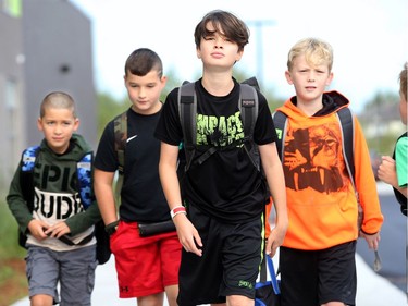 From left: Jacob Hassoun, 6, Hudson Hislop, 10, Wesley Parker, 11, Darius Ritchie, 10 and Milo Parker, 7, stride into school. It was the first day back at school for kids in Ottawa's public board Tuesday (Sept. 5, 2017). However, for almost 600 children, it was their first day at a new school, Vimy Ridge Public School, which opened Tuesday in Findlay Creek and held an opening ceremony outside, complete with a flag raising and veteran bagpiper.  Julie Oliver/Postmedia
Julie Oliver, Postmedia