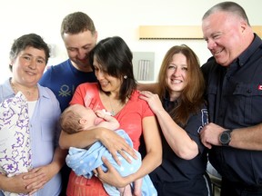 Yuriy and Oksana Shelkovyy - the parents of two-month-old Nikita, who was saved last week by strangers who gave their son CPR - greet their heroes at CHEO Monday. They include PSW Geraldine Carvalho (left), ambulance dispatcher Sandra Dinel (second from right) and City of Ottawa parking officer, David McEvoy (far right).