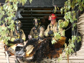 Firefighters clean out one of the apartments at 292 Lajoie Street in Vanier. Eight people, including several teens, were displaced and one person suffered smoke inhalation from the house fire.