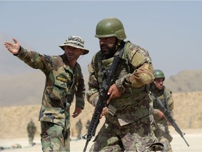 In this photograph taken on August 10, 2017, an Afghan commando instructor explains how to fire during live firing exercises at Camp Morehead on the outskirts of Kabul.