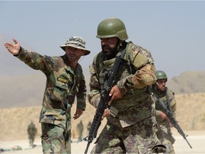 In this photograph taken on August 10, 2017, an Afghan commando instructor explains how to fire during live firing exercises at Camp Morehead on the outskirts of Kabul. Fresh recruits to Afghanistan's elite special operations forces will soon be on the frontline of the war against a resurgent Taliban -- a battle US President Donald Trump has vowed "to win" by putting more American boots on the ground indefinitely. SHAH MARAI, AFP/Getty Images