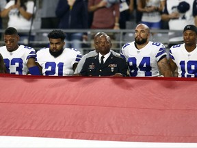 The Dallas Cowboys stand during the national anthem prior to an NFL football game against the Arizona Cardinals, Monday, Sept. 25, 2017, in Glendale, Ariz.