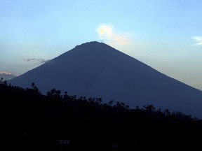 Mount Agung volcano is seen at sunset in Karangasem, Bali, Indonesia, Thursday, Sept. 28, 2017. More than 120,000 people have fled the region around the Mount Agung volcano on the Indonesian tourist island of Bali, fearing it will soon erupt, an official said Thursday. (AP Photo/Firdia Lisnawati)
