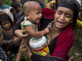 A Rohingya woman breaks down after a fight erupted during food distribution by local volunteers at Kutupalong, Bangladesh, Friday, Sept. 8, 2017. Members of a local organization were seen distributing aid, throwing packets of puffed rice and old clothes into huge crowds of Rohingya. There are no clearly organized points of distribution. U.N. agencies have released $8 million in emergency aid in the area, but were pleading for millions more. (AP Photo/Bernat Armangue) ORG XMIT: BA105
Bernat Armangue, AP