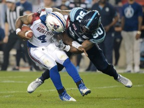 Alouettes quarterback Darian Durant is hit by Argonauts defensive lineman Cleyon Laing during the first half of Saturday's game at BMO FIeld in Toronto. THE CANADIAN PRESS/Jon Blacker