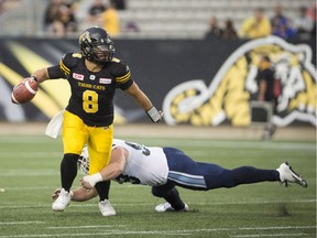 Tiger-Cats quarterback Jeremiah Masoli (8) eludes Argonauts defensive lineman Dylan Wynn, but ends up throwing an interception in Monday's game at Tim Hortons Field in Hamilton. THE CANADIAN PRESS/Peter Power