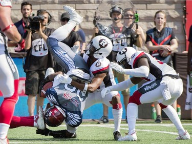 Montreal Alouettes' Tyrell Sutton is upended by Ottawa Redblacks defenders during first half CFL football action against the Ottawa Redblacks in Montreal, Sunday, September 17, 2017.