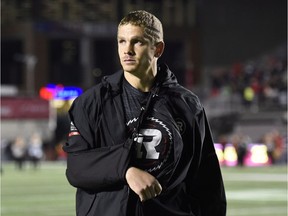 Redblacks quarterback Trevor Harris, who was injured in the third quarter, walks off the field with his right arm in a sling following Saturday's game. THE CANADIAN PRESS/Justin Tang