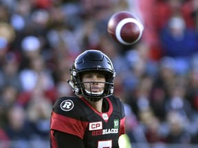 The ball floats over the head of Ottawa Redblacks quarterback Trevor Harris (7) after a throw against the Hamilton Tiger-Cats during the first half of a CFL football game in Ottawa on Saturday, Sept. 9, 2017.