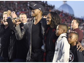 Former Redblacks quarterback Henry Burris, his wife Nicole and their sons Armand and Barron watch career highlights on the video screen at TD Place stadium during Burris's Wall of Honour ceremony on Sept. 9. THE CANADIAN PRESS/Justin Tang