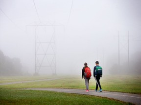 Youngsters walk along the path near Greenbank Rd. as fog envelops the Ottawa region on Wednesday morning.   Photo Wayne Cuddington/ Postmedia
Wayne Cuddington, Postmedia