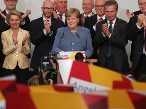 Angela Merkel, Germany's chancellor and Christian Democratic Union (CDU) leader, centre, reacts during celebrations following the federal elections at the CDU headquarters in Berlin, Germany.