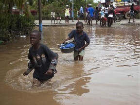Boys wade through flood waters caused by heavy rains brought on by Hurricane Irma, in Fort-Liberte, Haiti, Friday Sept. 8, 2017. Irma rolled past the Dominican Republic and Haiti and battered the Turks and Caicos Islands early Friday with waves as high as 20 feet (6 meters). ( AP Photo/Dieu Nalio Chery) ORG XMIT: DC104
Dieu Nalio Chery, AP