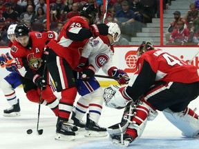 The Senators' Mark Stone, left, clears the puck from in front of the net as Johnny Oduya (29), goaltender Craig Anderson (41) and the Canadiens' Tomas Plekanec (14) look on during the first period of Saturday's game. THE CANADIAN PRESS/Fred Chartrand