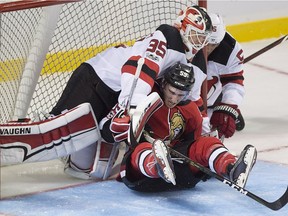 Ottawa Senators Alex Formenton is knocked into New Jersey Devils goaltender Cory Schneider during second period NHL preseason hockey action in Summerside, P.E.I., on Monday, Sept. 25, 2017.